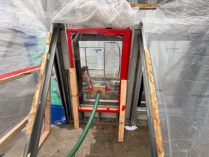 Water leakage testing of a window assembly using a hose during building construction.